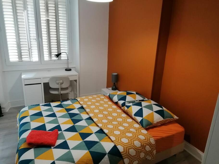a bedroom with a bed with a colorful blanket at Appartement meublé proche du centre - Wifi&#47;Parking in Clermont-Ferrand