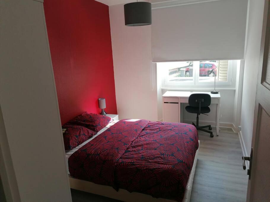 a red bedroom with a bed and a desk at Appartement meublé proche du centre - Wifi&#47;Parking in Clermont-Ferrand