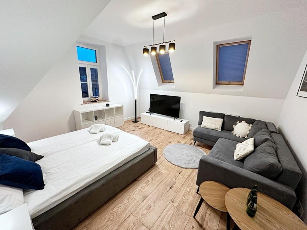 sypialnia z dużym łóżkiem i kanapą w obiekcie Apartamenty Kamienica Gwiazda w mieście Krynica Zdrój