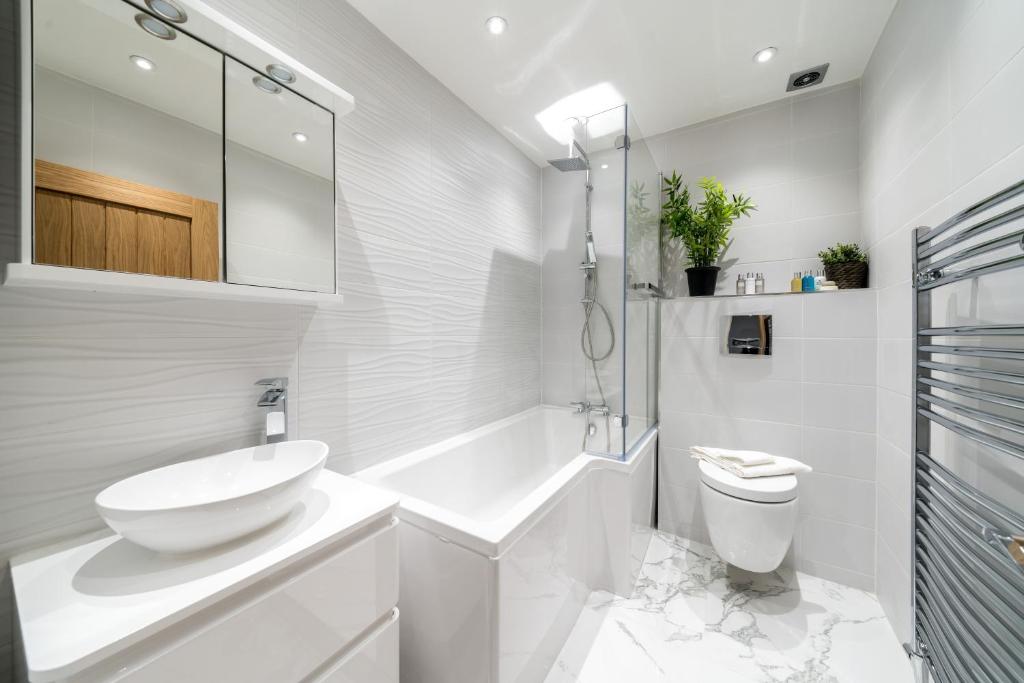 ein weißes Bad mit einem Waschbecken und einem WC in der Unterkunft Stunning 2 Bed 2 Bath Luxury London Apartment! in Forest Hill