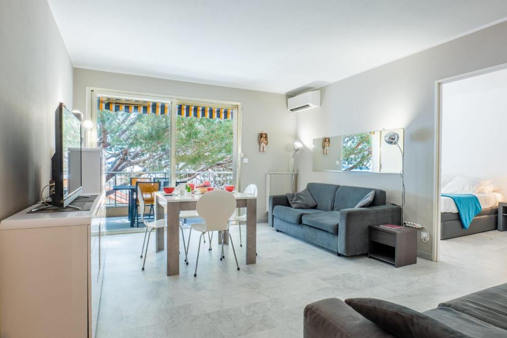 un salon avec une table et un canapé dans l'établissement 2-Room Apartment with Terrace Sea View, à Cannes