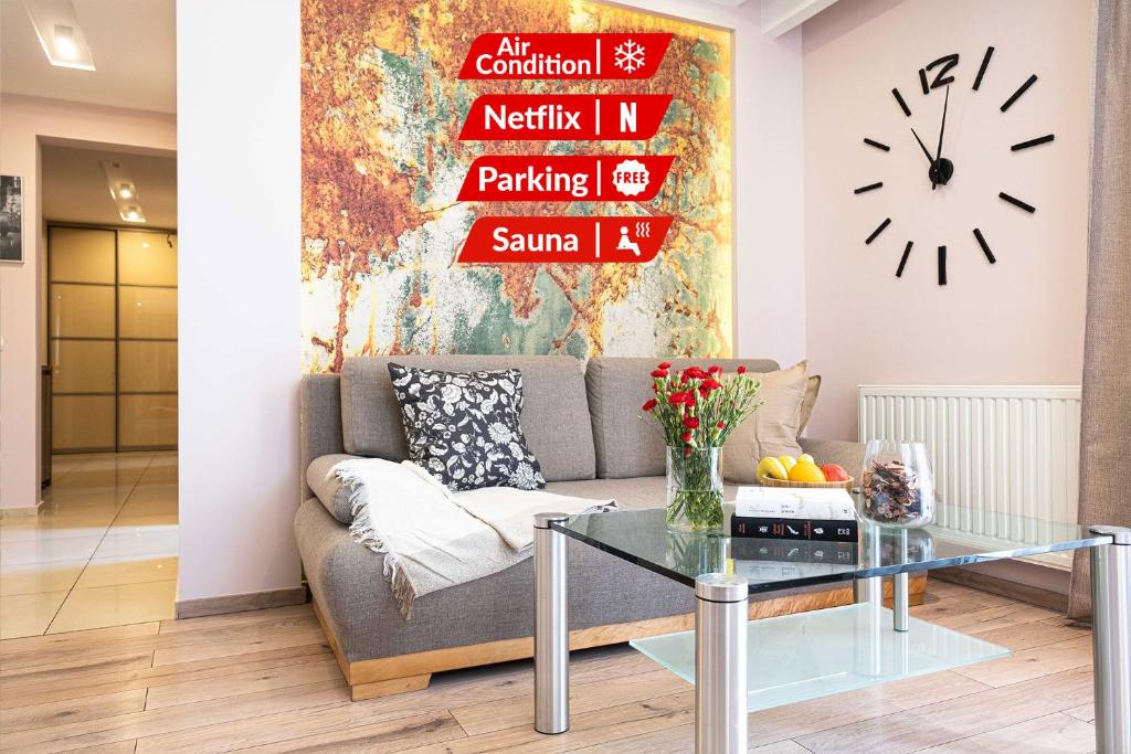 ein Wohnzimmer mit einem Sofa und einem Tisch in der Unterkunft Stawowa Premium Apartment - 69 m2 with sauna and private garage in Krakau