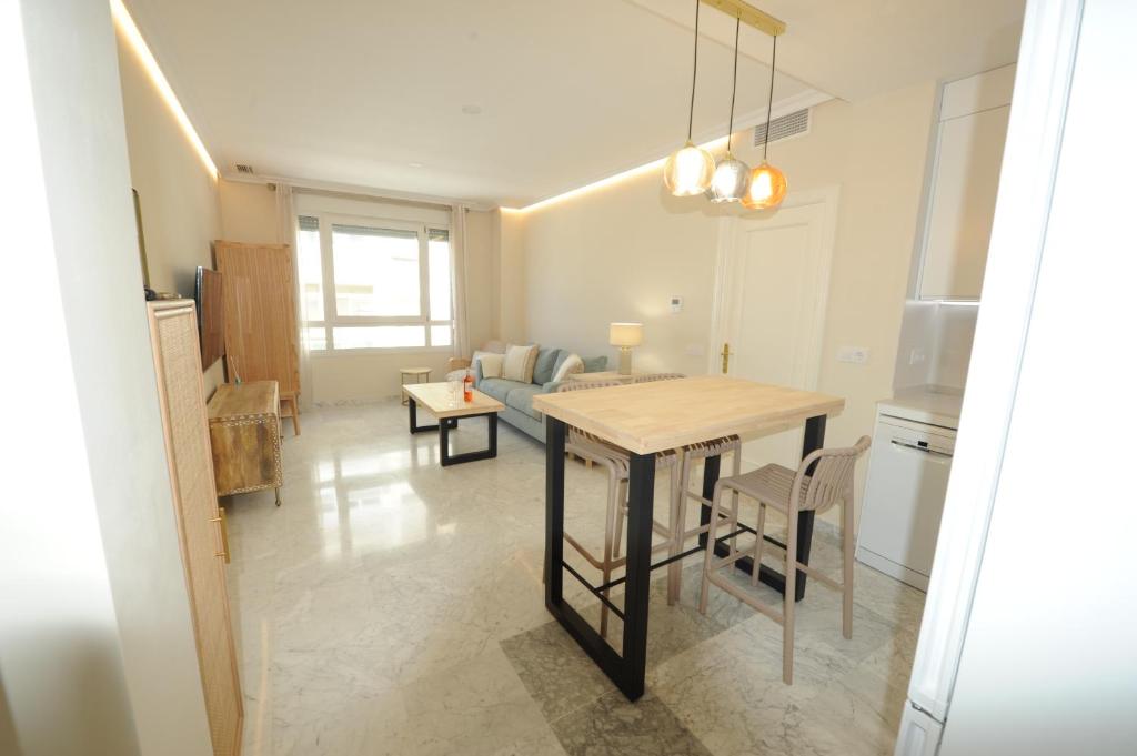 eine Küche und ein Wohnzimmer mit einem Tisch und einem Sofa in der Unterkunft Apartamento reformado con vistas al mar in Cádiz