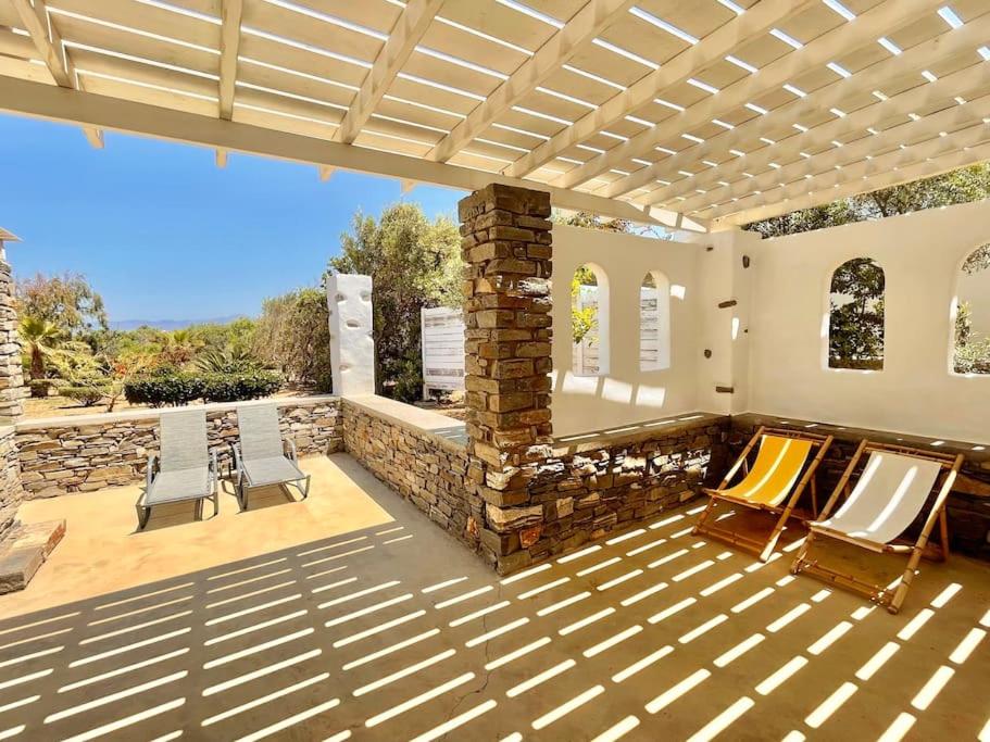 a patio with two chairs and a stone fireplace at Villa Santa Maria-Sophia in Kampos Paros