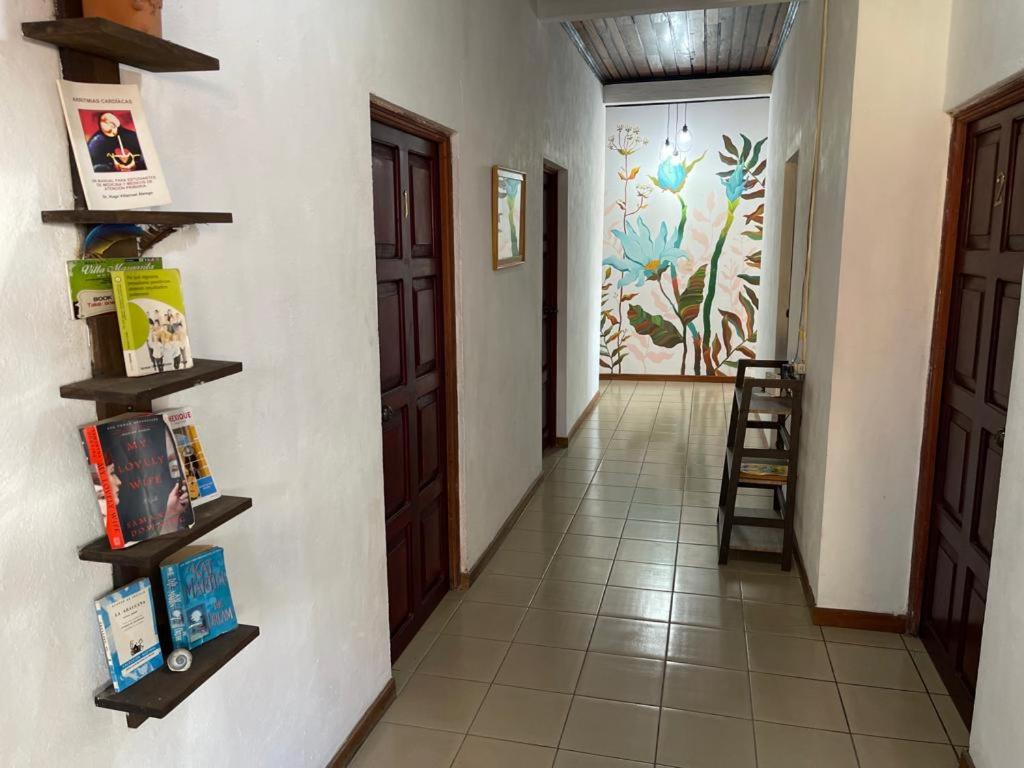 un pasillo con estanterías en la pared y una puerta en Hotel Villa Margarita en Flores
