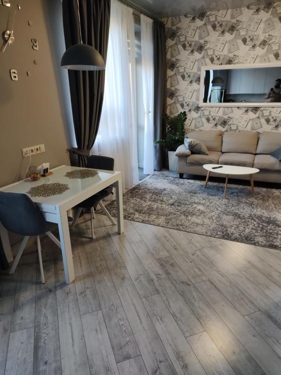 a living room with a table and a couch at Романтичні апартаменти на центральному проспекті, великий Smart TV,преміум-підписки, кавомашина, відкритий балкон in Kryvyi Rih