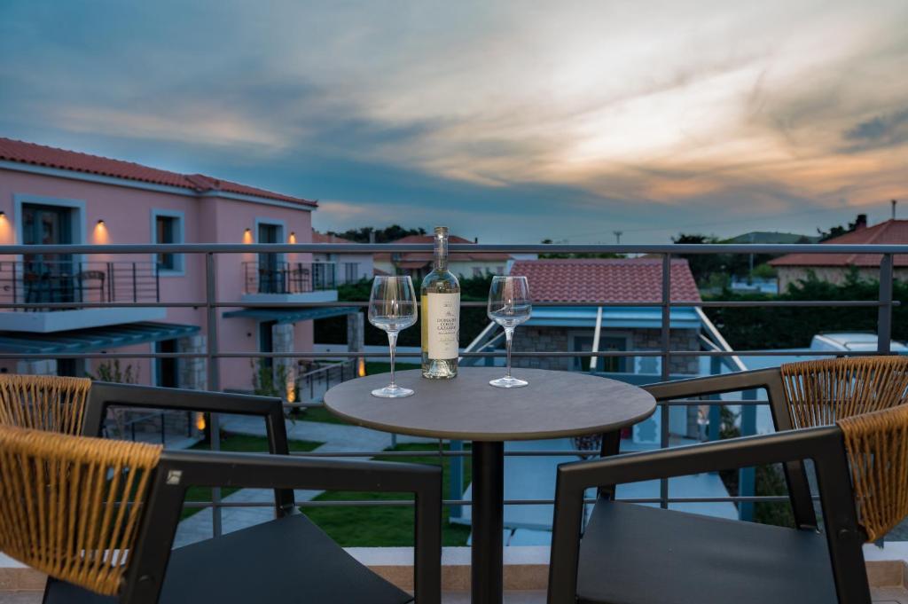 a table with two glasses of wine on a balcony at Nissos Apartments in Myrina