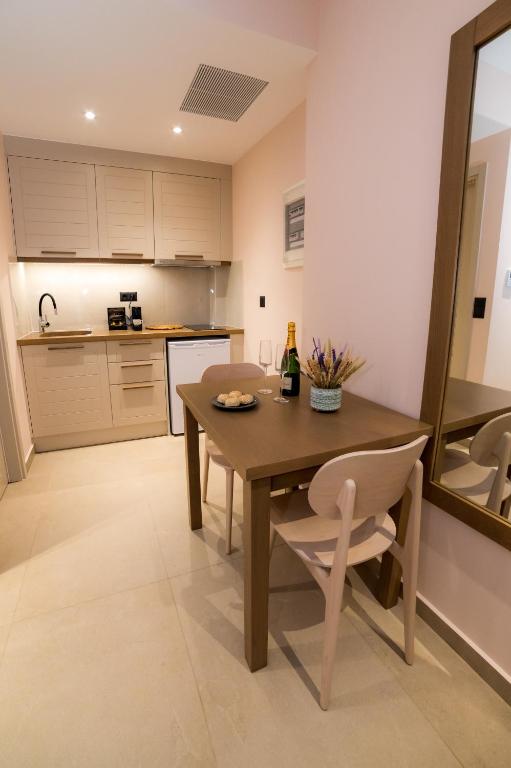 a kitchen with a wooden table and a bottle of wine at Nissos Apartments in Myrina