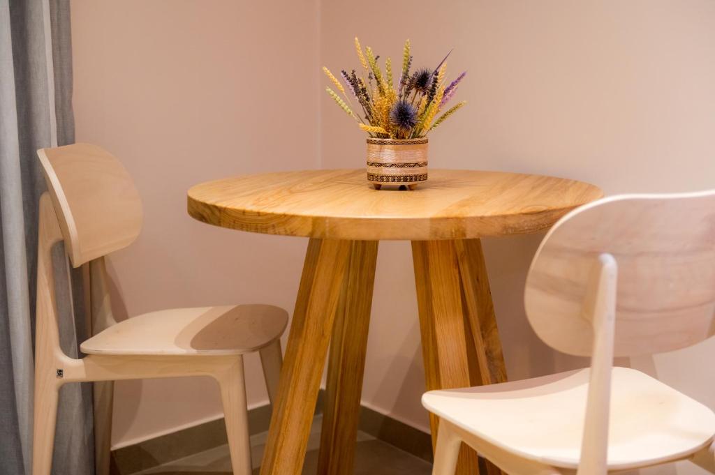 a small wooden table with a vase of flowers on it at Nissos Apartments in Myrina