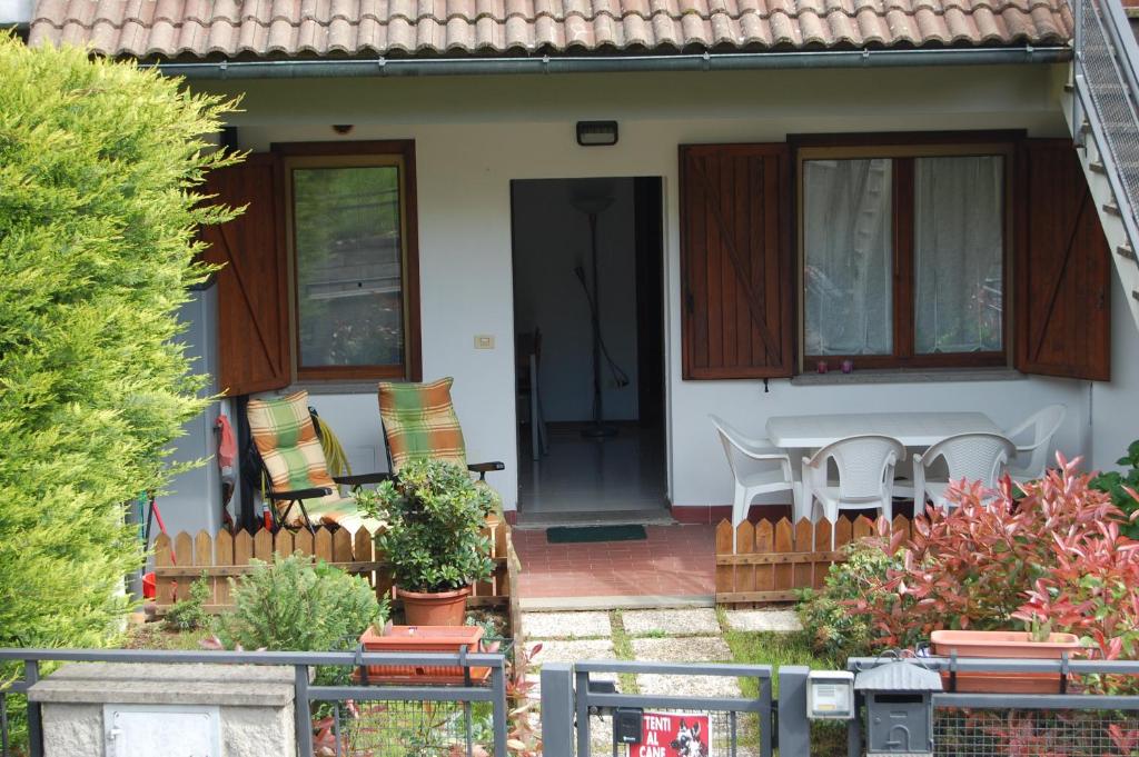 a house with a porch with a table and chairs at La casina delle viole in Abbadia San Salvatore