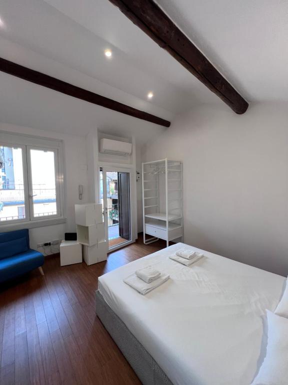 sypialnia z białym łóżkiem i niebieską kanapą w obiekcie Skyline Silence Suite w Mediolanie