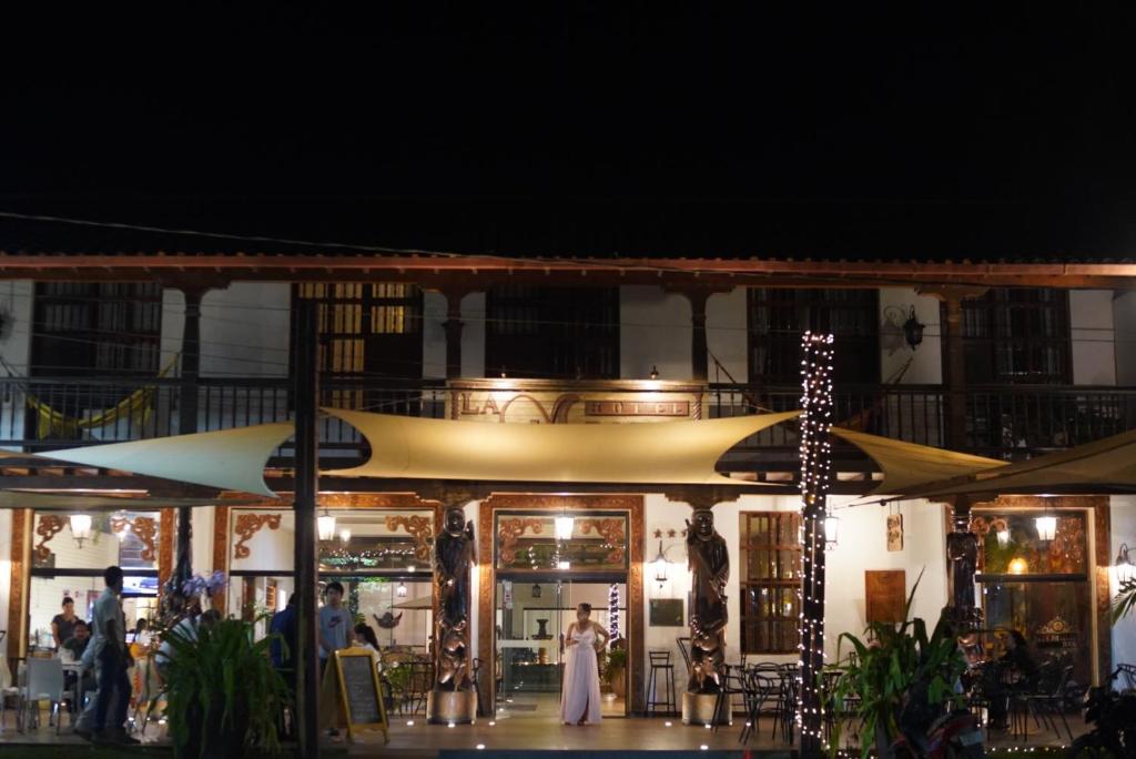 Una novia y un novio parados frente a un restaurante por la noche en Hotel La Mision, en San Ignacio de Velasco