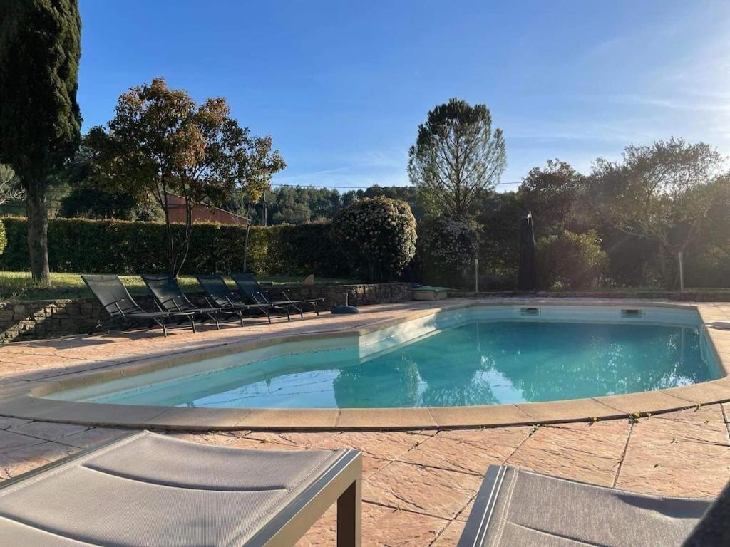 a swimming pool with two chairs at Villa Comorebi Provence in Entrecasteaux