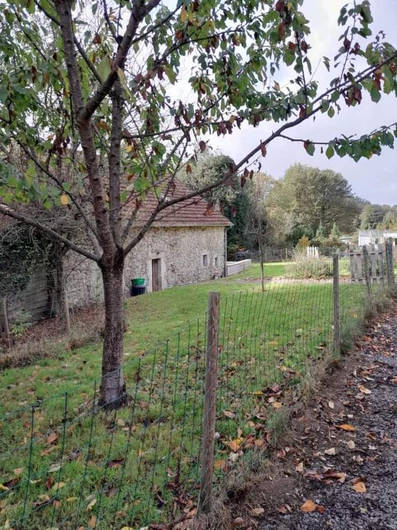 une clôture devant une maison avec un arbre dans l'établissement Badger Cottage, à Salagnac