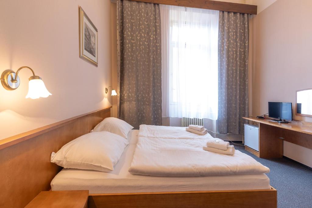 Postel nebo postele na pokoji v ubytování Hotel Slovan Plzeň
