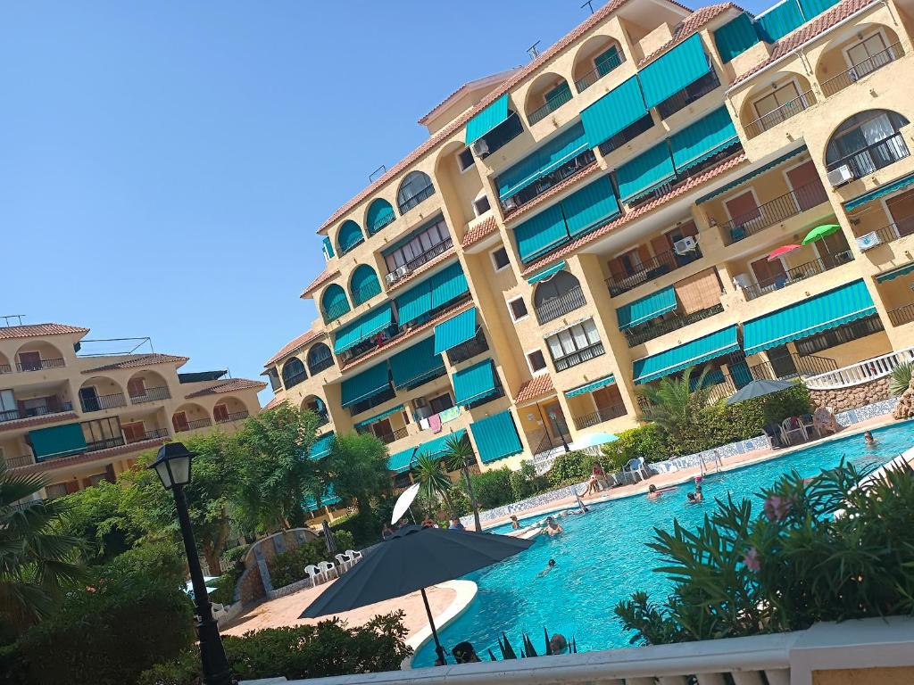 un hotel con piscina frente a un edificio en Apartamento en la playa, en La Mata