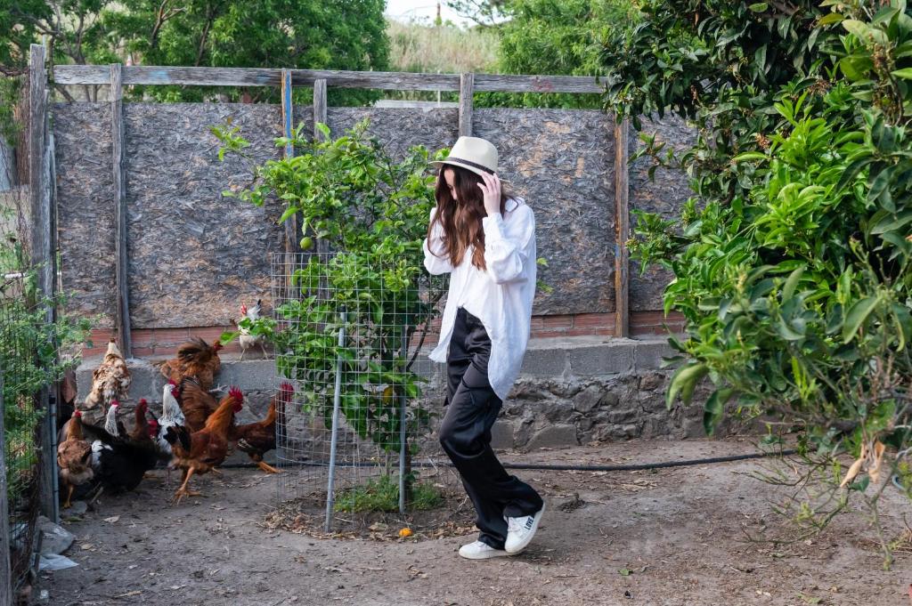 a woman talking on a cell phone in front of chickens at Nissos Apartments in Myrina