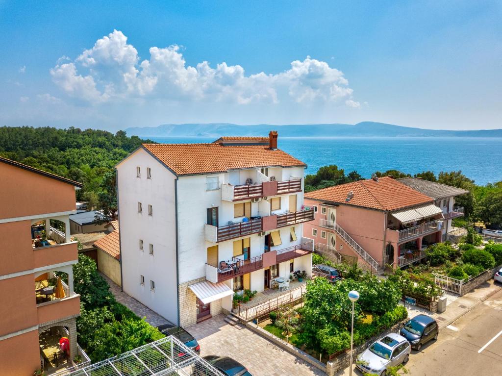 セルツェにあるApartmani Sunčica Selceの水辺の景色を望むアパートメントビル