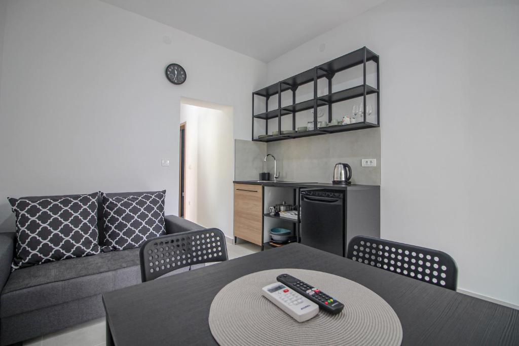 a living room with a couch and a table with remote controls at Apartman Toni in Rogoznica