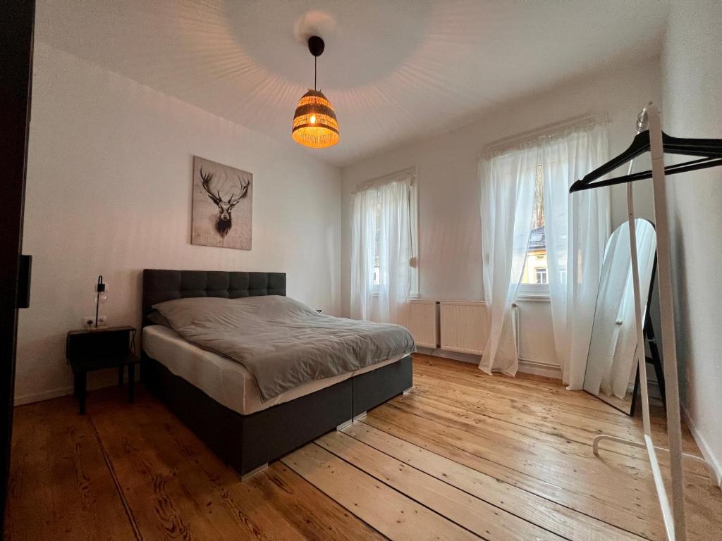 a bedroom with a bed and a lamp on a wooden floor at Vintage Apartment 1 am Kurpark von Bad Ems in Bad Ems