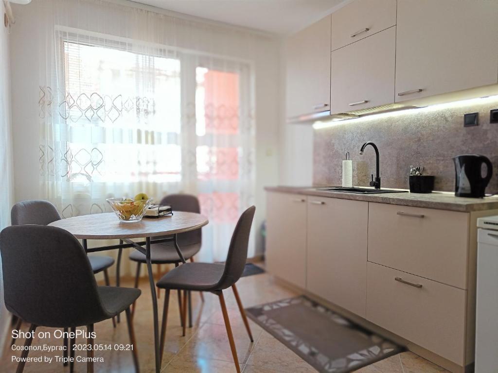 eine Küche mit einem Tisch, Stühlen und einem Waschbecken in der Unterkunft Moni 85 Family House in Sozopol