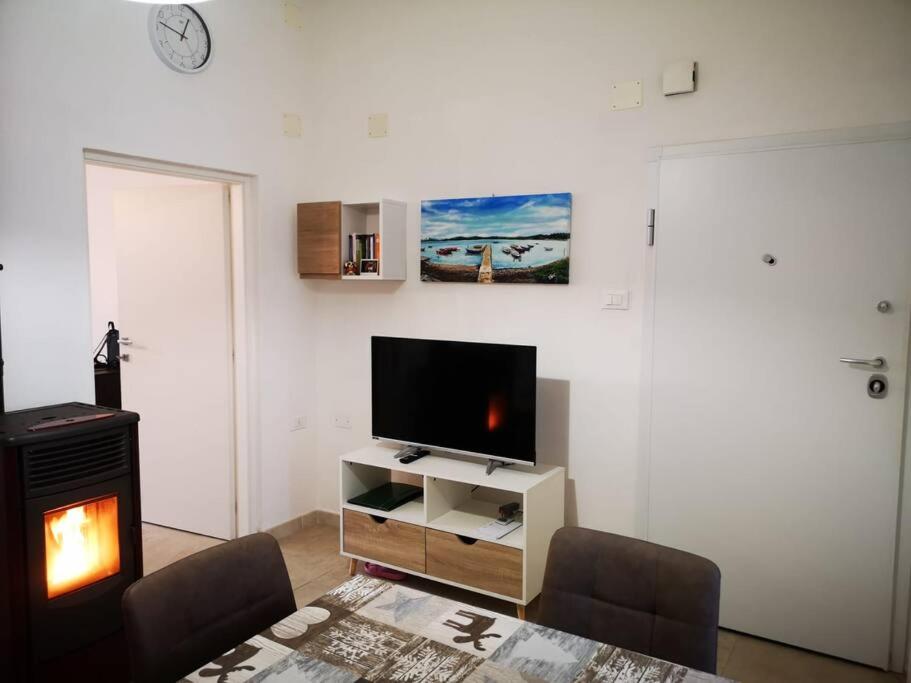ein Wohnzimmer mit einem TV und einem Kamin in der Unterkunft La Casa Vacanze di Bea in Venturina Terme