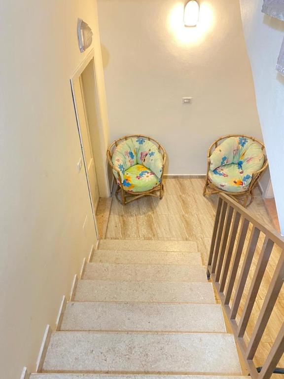 2 chaises assises sur les escaliers dans une pièce dans l'établissement Omar home, à Madaba