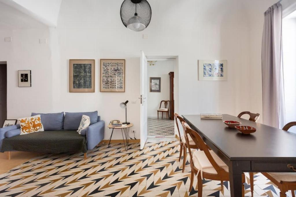 - un salon avec une table et un canapé dans l'établissement Casa Calderai art and design, à Palerme