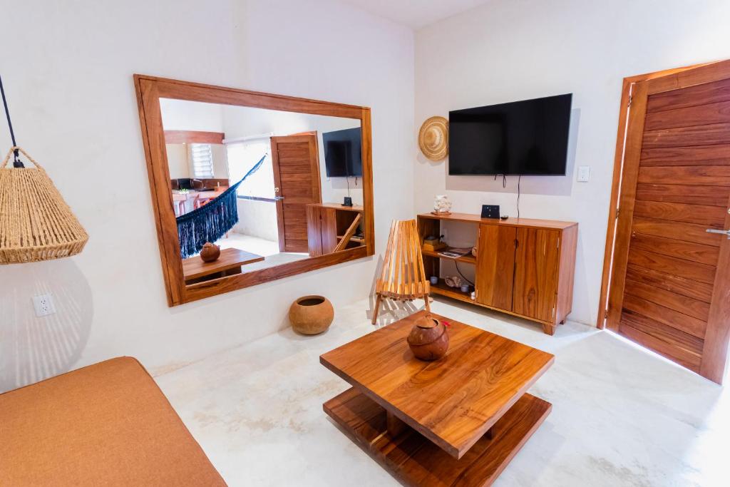 een woonkamer met een tv en een houten tafel bij Casita con cama King, tina de baño, A/A y Netflix in Bacalar