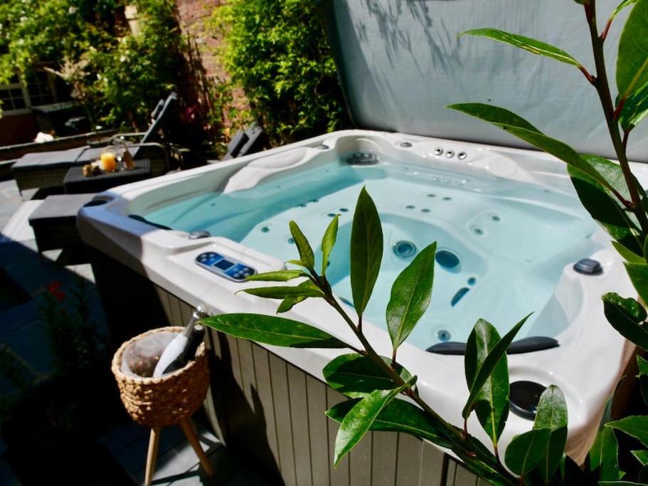 un jacuzzi con una planta al lado en Contractors Deluxe Essex Short Stay House In Saffron Walden Near Cambridge, en Saffron Walden