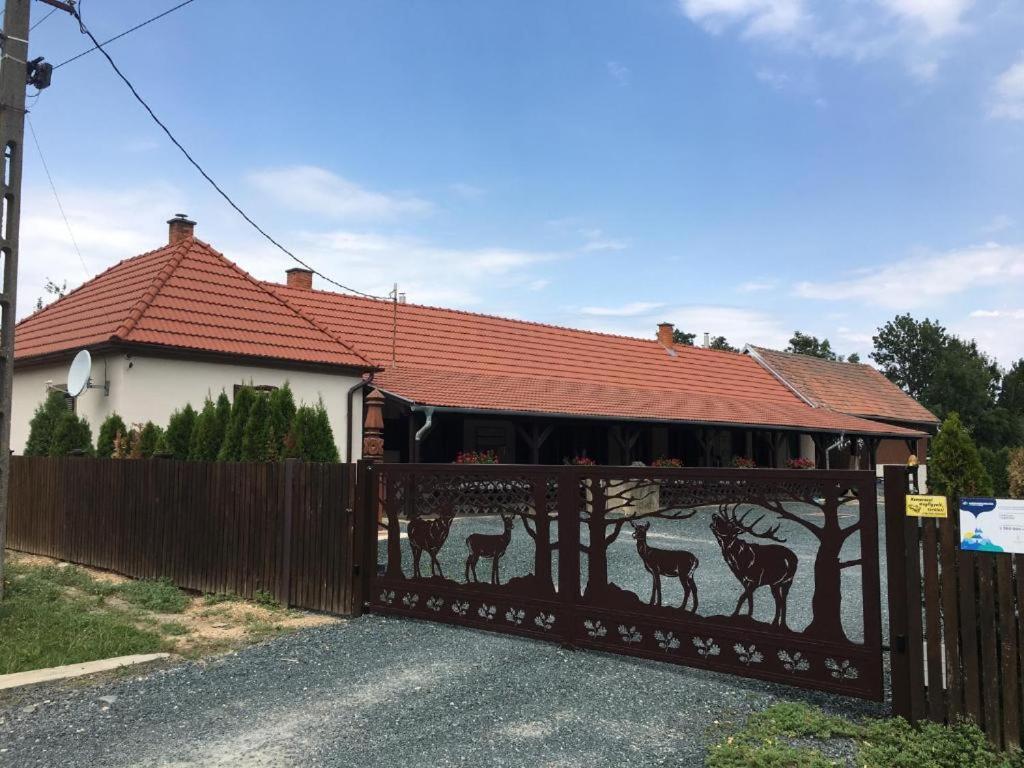 uma casa com um portão com girafas pintadas nela em Vadászház em Rádócújfalu