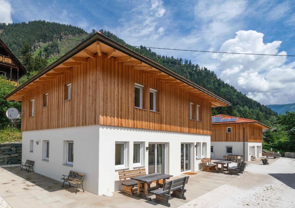 ein Gebäude mit einem Holzdach und einem Picknicktisch in der Unterkunft 1Schönes Ferienhaus im sonnigen Kärnten in Döbriach