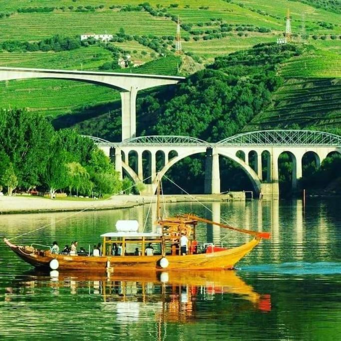 a yellow boat on the water in front of a bridge at Casa do Trovão - Douro in Peso da Régua