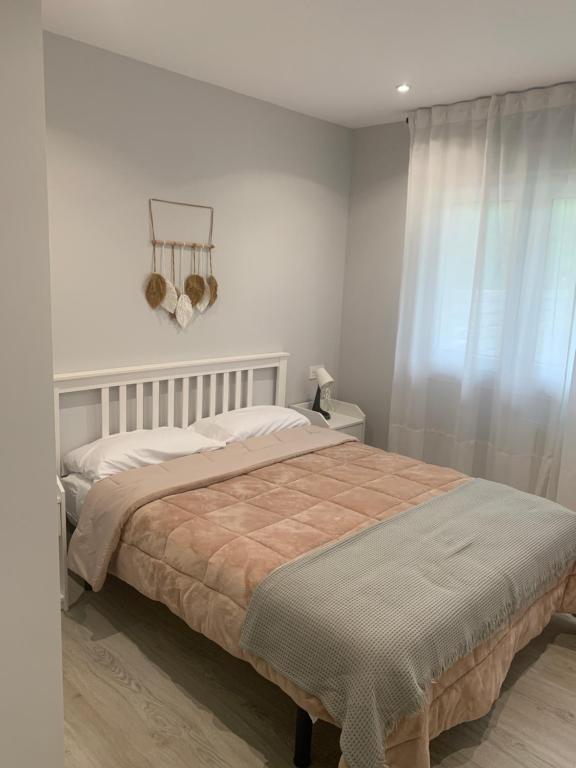 ein Schlafzimmer mit einem großen Bett mit weißen Wänden in der Unterkunft Apartamentos Cañamal in Llanes