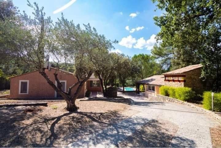 una casa con un árbol en medio de una entrada en Villa Comorebi Provence, en Entrecasteaux