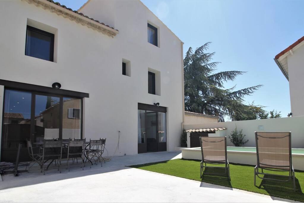 a patio with chairs and a table in front of a building at Maison de village 150 M2 au calme climatisée, piscine in Rasteau