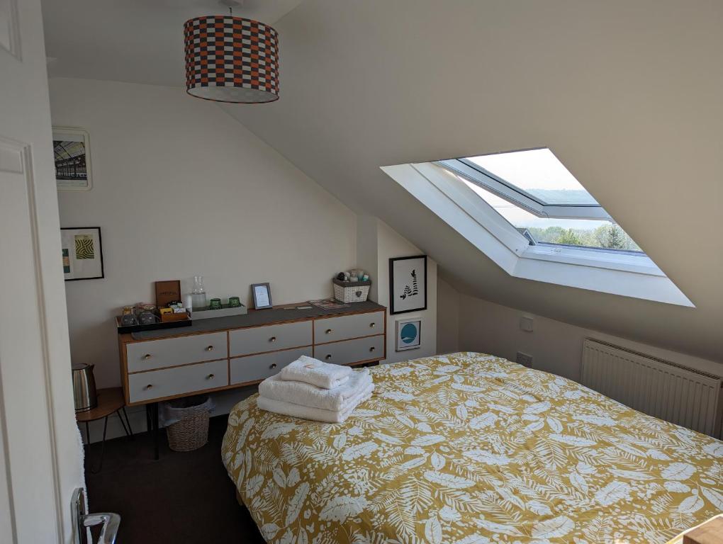 Schlafzimmer im Dachgeschoss mit einem Bett und einem Dachfenster in der Unterkunft South Downs View in Brighton & Hove