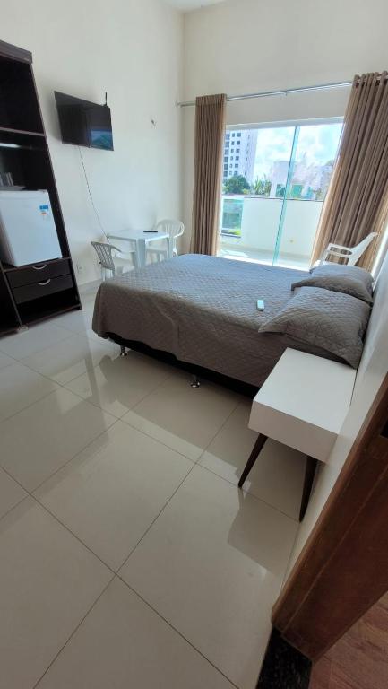 um quarto com uma cama e uma janela grande em Orla Graciosa em Palmas