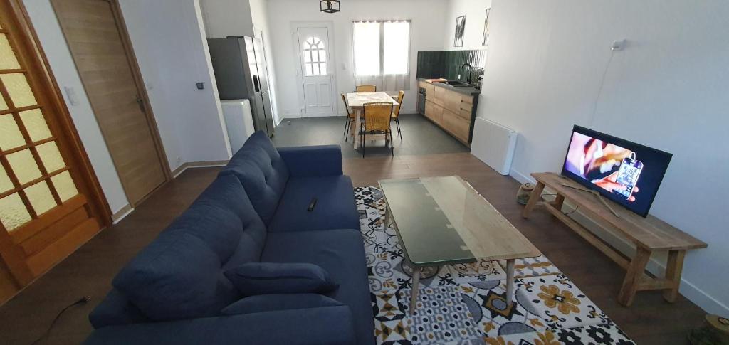 a living room with a blue couch and a tv at El Dar in Cholet
