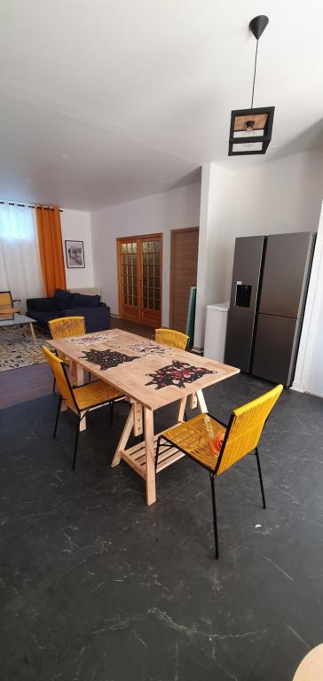 a wooden table and chairs in a living room at El Dar in Cholet