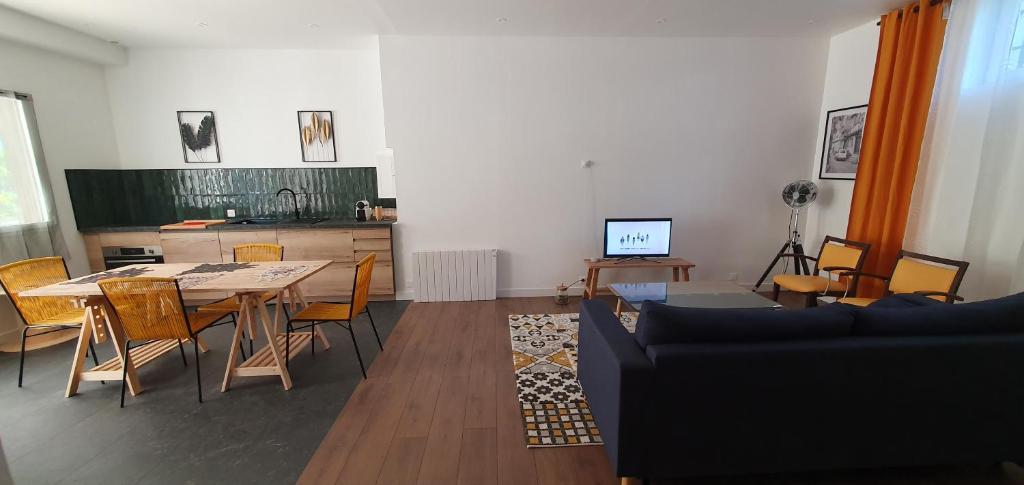 a living room with a table and chairs and a kitchen at El Dar in Cholet