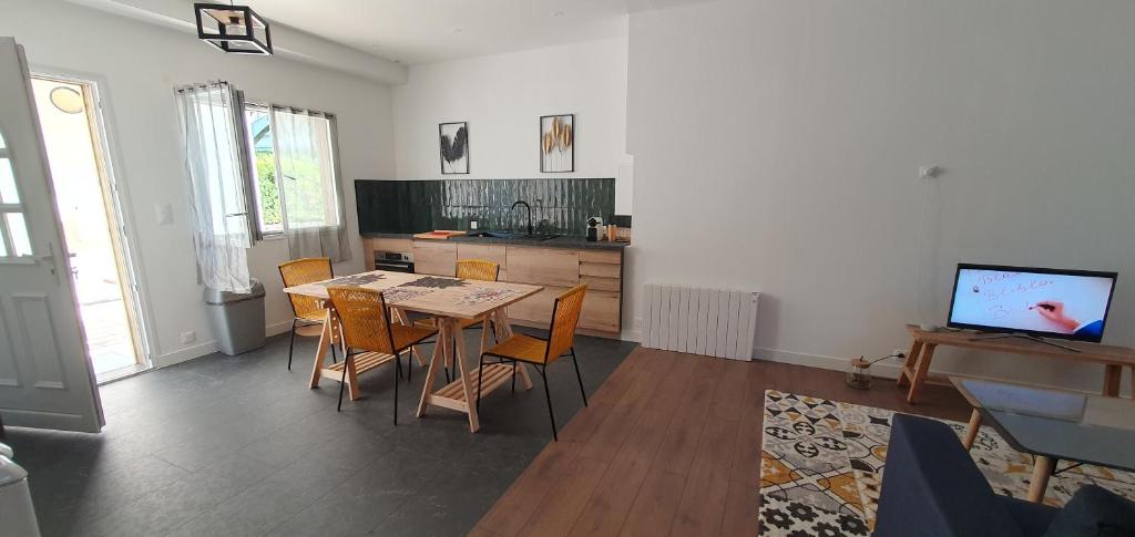 a living room with a table and chairs and a kitchen at El Dar in Cholet