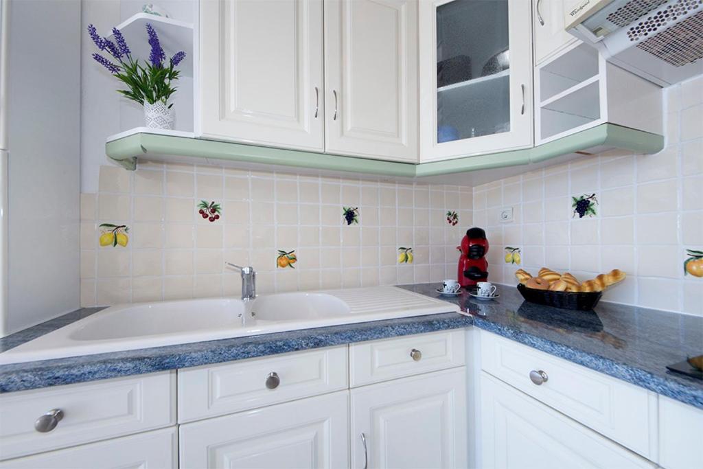 a kitchen with white cabinets and a sink at Piso Sofia in Empuriabrava