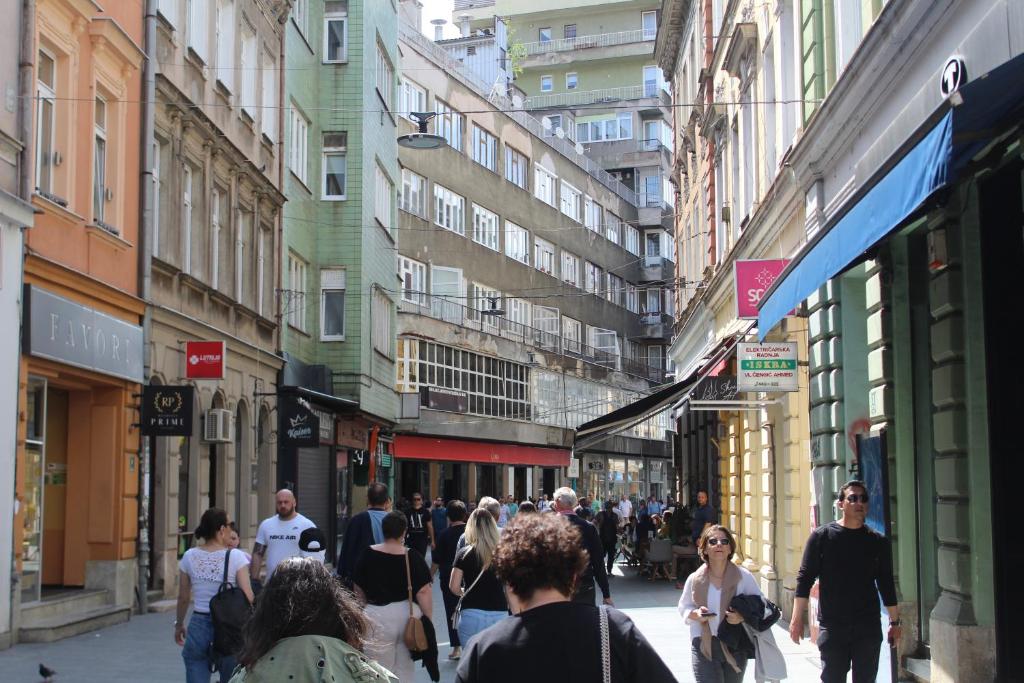 um grupo de pessoas andando por uma rua movimentada da cidade em Red Apartment em Sarajevo