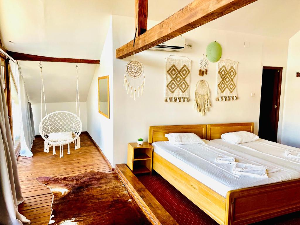 a bedroom with a large bed and a chair at ZEN Eco Villa in Sfântu Gheorghe