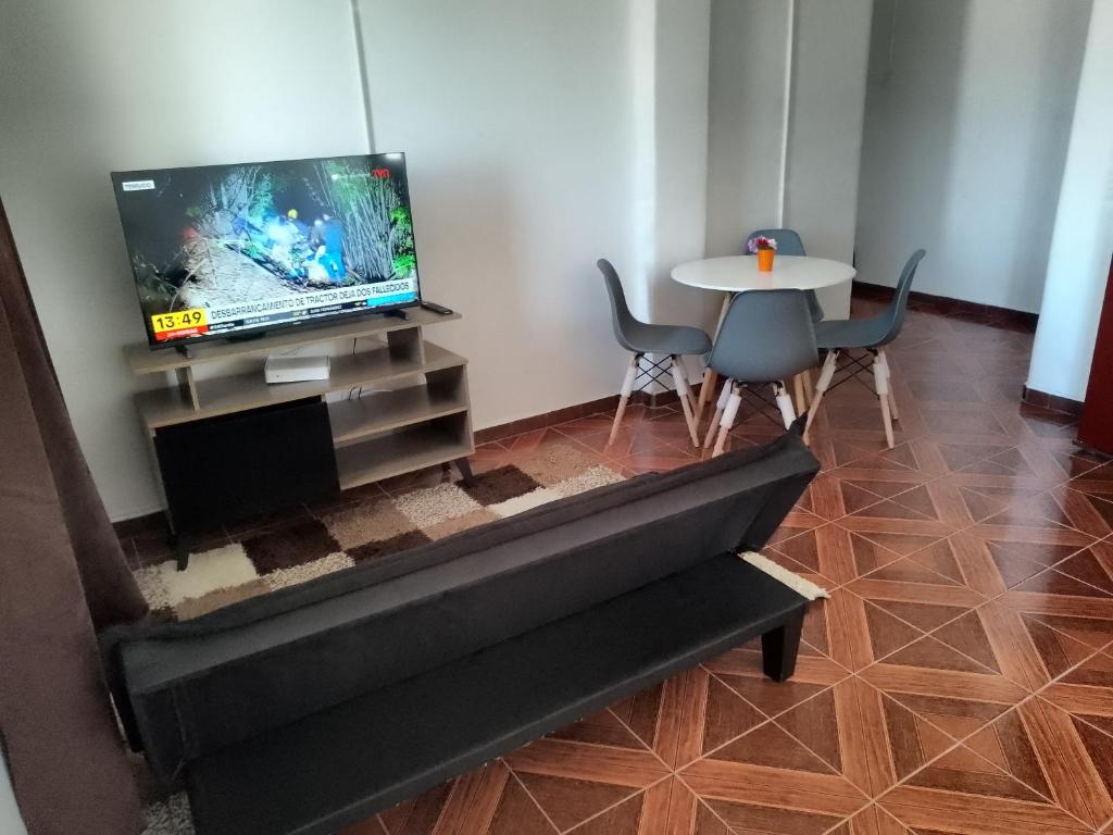 a living room with a tv and a table with chairs at Departamento monoambiente centrico in Arica