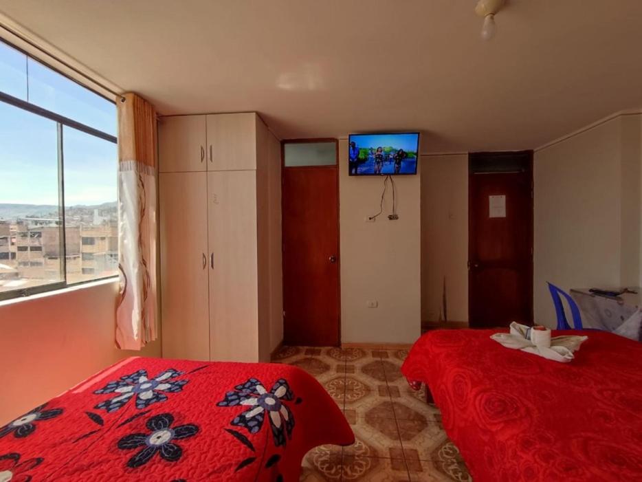 a bedroom with a red bed and a television in it at Hotel San Francisco in Cajamarca