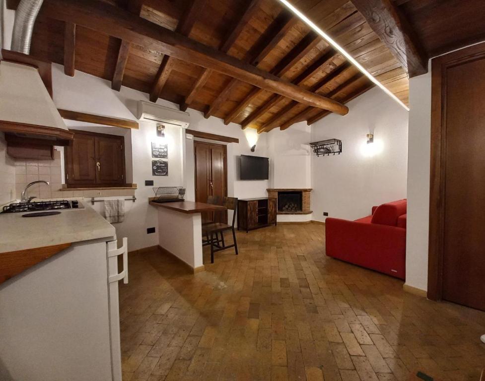 Il comprend une cuisine et un salon avec un canapé rouge. dans l'établissement Il Loft del Lago, à Anguillara Sabazia