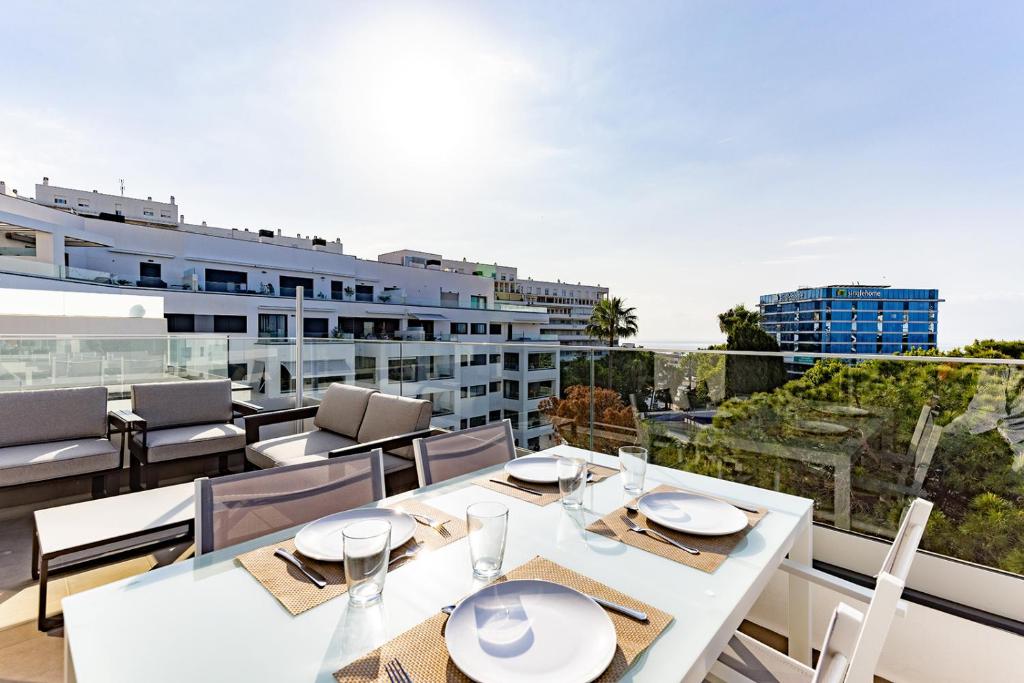 a white table and chairs on the balcony of a building at Brand new apartment with pool and SEA VIEW in Marbella in Marbella
