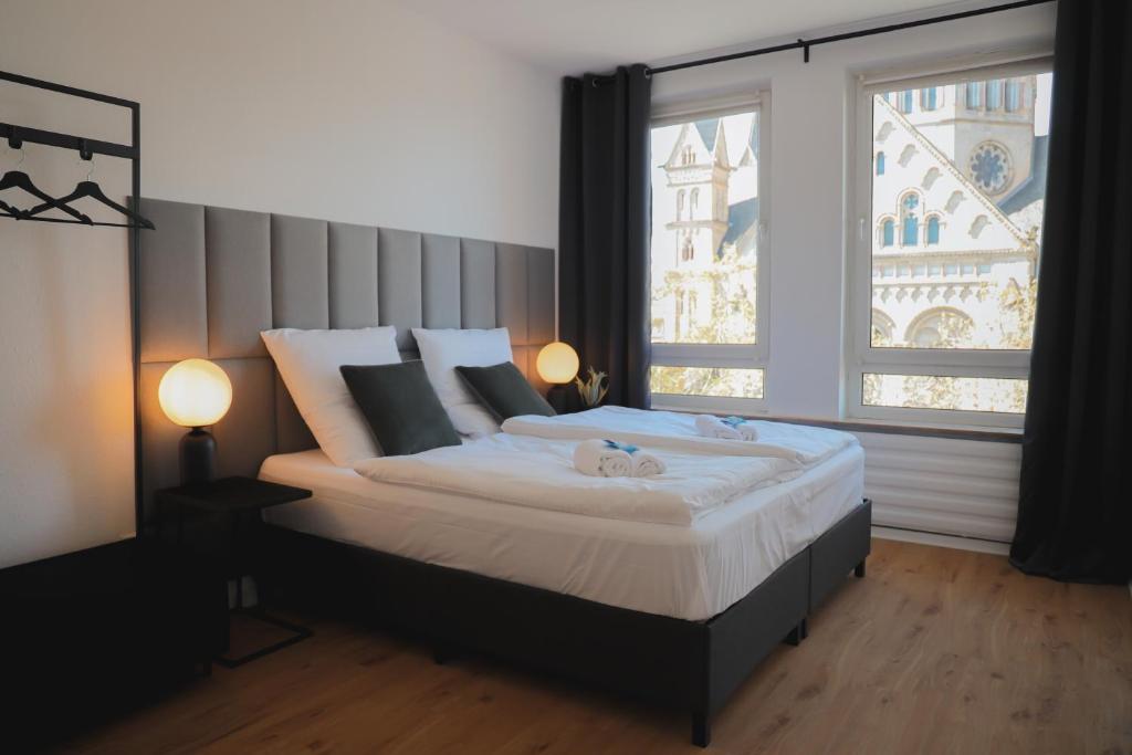 een slaapkamer met een groot bed en een groot raam bij JAWO Apartments im Herzen von Koblenz in Koblenz